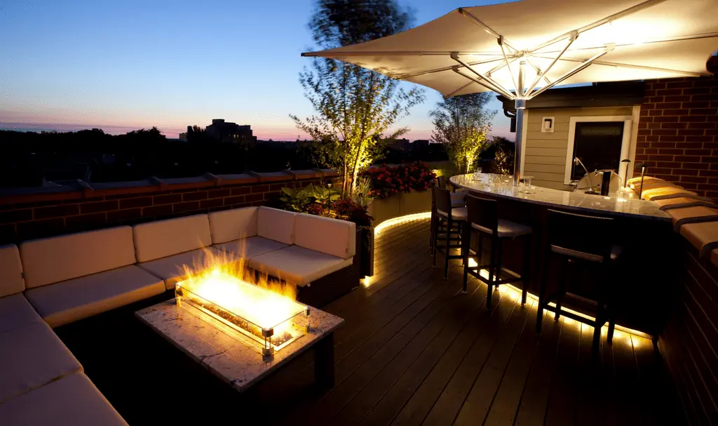 Fire table and outdoor kitchen at dusk.