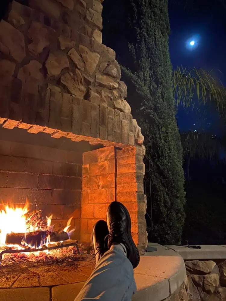 Lounging by the outdoor fireplace at night.