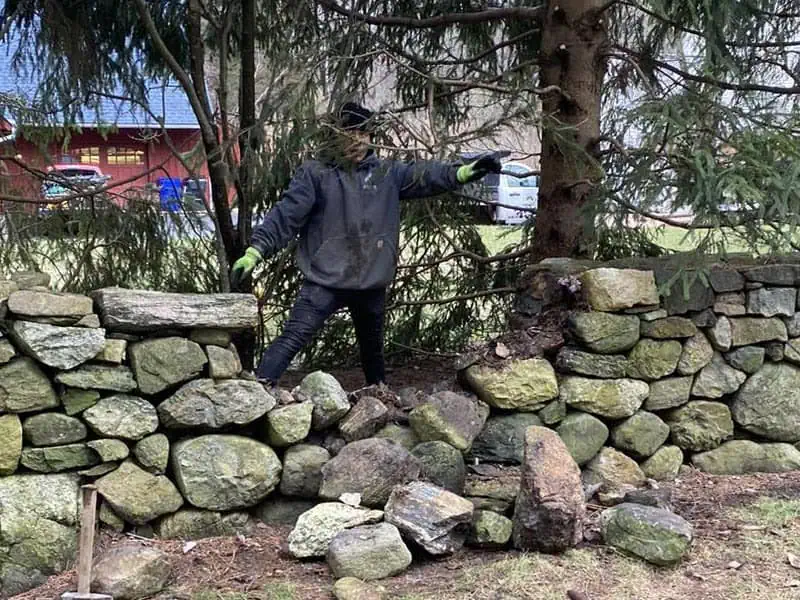 Masonry repair Stone fence crumbled.
